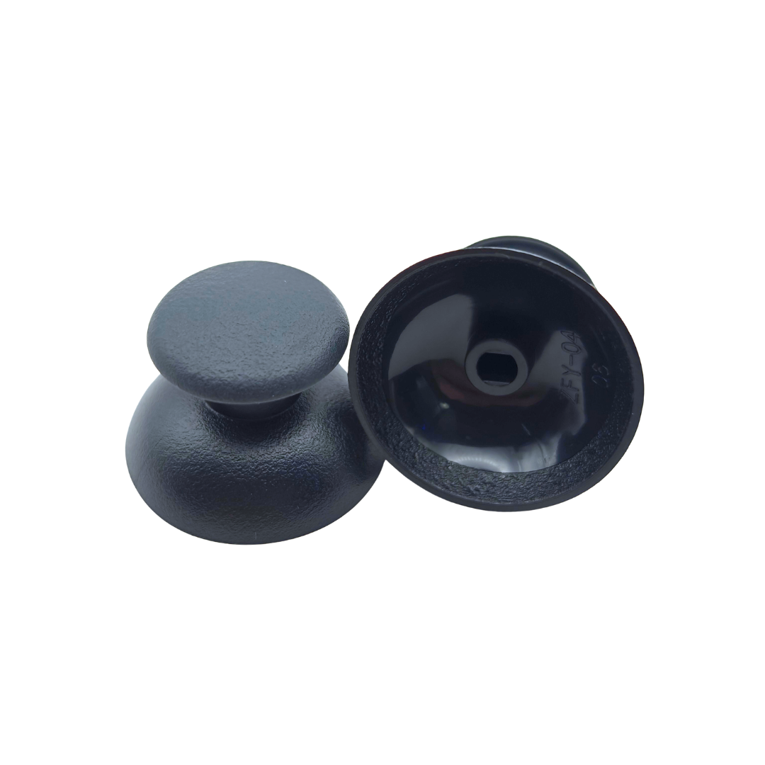 Pair of black controller thumbsticks, with one shown upright and the other showing the underside attachment socket on a white background
