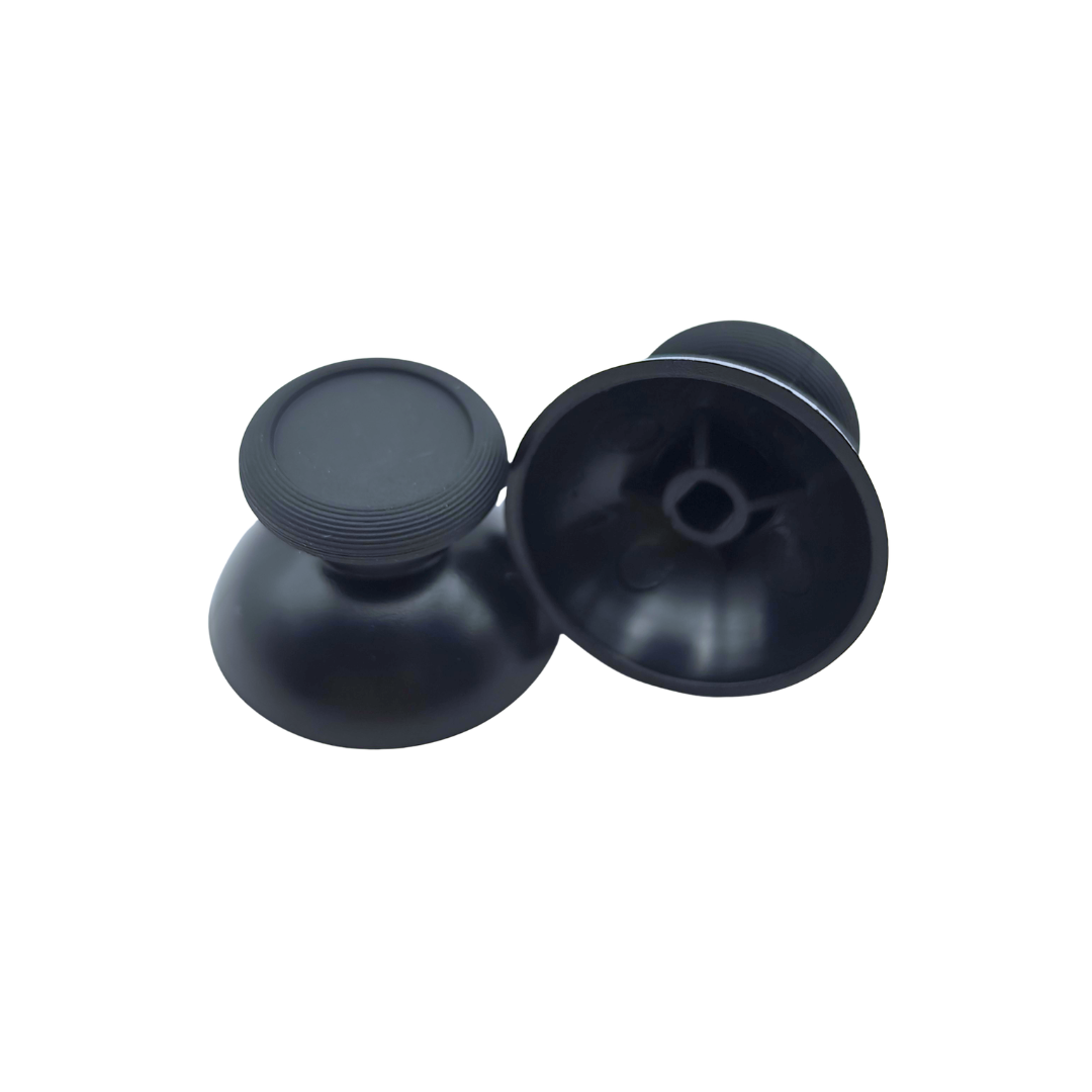 Pair of black controller thumbsticks, with one shown upright and the other showing the underside attachment socket on a white background
