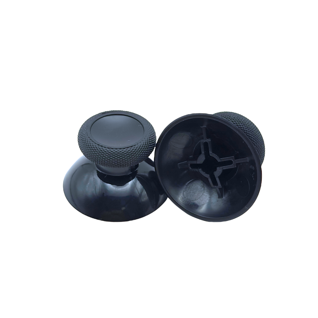 Pair of black controller thumbsticks, with one shown upright and the other showing the underside attachment socket on a white background
